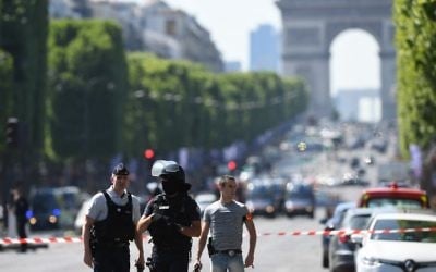 Policemen stand guard on the Champs-Elysees avenue in Paris, after a car crashed into a police van before bursting into flames, June 19, 2017. (AFP/ALAIN JOCARD)