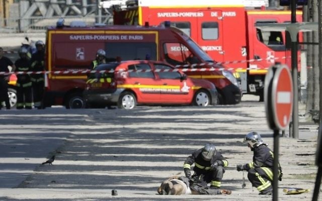 Rescuers tend to the body of a suspect lying in a sealed off area of the Champs-Elysees avenue in Paris, on June 19, 2017. (AFP/Thomas Samson) Rescuers tend to the body of a suspect lying in a sealed off area of the Champs-Elysees avenue in Paris, on June 19, 2017. (AFP/Thomas Samson)