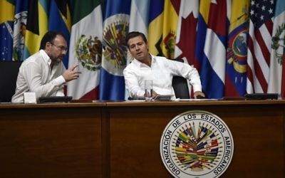 Mexican President Enrique Pena Nieto (R) and Foreign Minister Luis Videgaray gesture during the opening ceremony of the OAS 47th General Assembly in Cancun, Mexico, on June 19, 2017. (AFP/Pedro Pardo)