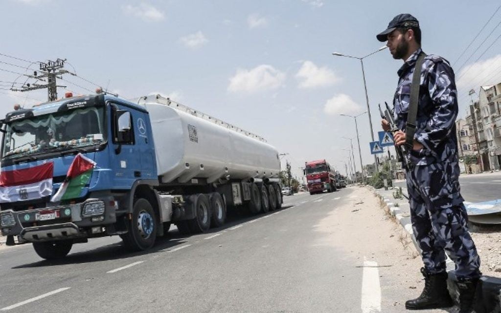 Palestinian security forces stand guard as Egyptian trucks carrying fuel drive down a street after entering the southern Gaza Strip from Egypt through the Rafah border crossing on June 21, 2017. (AFP PHOTO / SAID KHATIB)