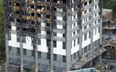 The unburned lower floors with untouched cladding still in place are pictured, with the burnt out upper floors above, at remains of the Grenfell Tower block in north Kensington, west London on June 22, 2017. (AFP PHOTO / NIKLAS HALLE'N)