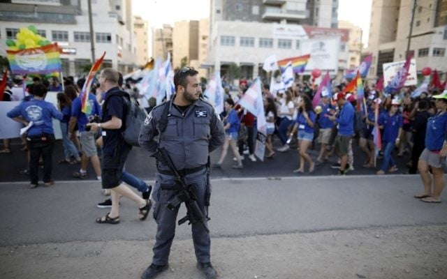 An Israeli policeman stands guard as Israelis take part in the first annual Gay Pride parade in the southern Israeli city of Beersheba, on June 22, 2017.(AFP PHOTO / MENAHEM KAHANA)