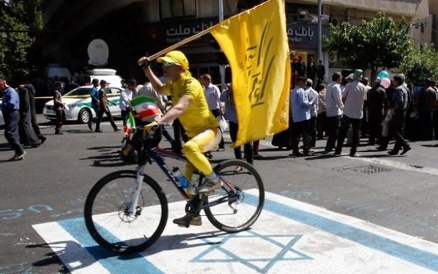 An Iranian man rides his bicycle on top of a reproduction of an Israeli flag painted on the street during a rally marking al-Quds (Jerusalem) Day in Tehran on June 23, 2017. (AFP Photo/Stringer) An Iranian man rides his bicycle on top of a reproduction of an Israeli flag painted on the street during a rally marking al-Quds (Jerusalem) Day in Tehran on June 23, 2017. (AFP Photo/Stringer)