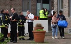 Residents (R) with belongings leave Burnham Tower residential block on the Chalcots Estate in north London on June 24, 2017 as residents evacuate because of fire safety concerns. ( AFP PHOTO / Justin TALLIS)