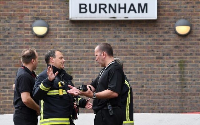 Firefighters are pictured outside Burnham Tower residential block on the Chalcots Estate in north London on June 24, 2017 as residents evacuate because of fire safety concerns.  (AFP PHOTO / Justin TALLIS)
