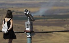 An Israeli tourist looks at the Syrian side of the border from Mount Bental, in the Golan Heights, on June 25, 2017.(AFP PHOTO / JALAA MAREY)