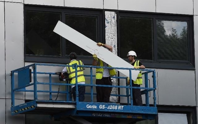 Workers remove cladding from the Whitebeam Court tower block in Salford, north west England on June 26, 2017. (AFP/PAUL ELLIS)