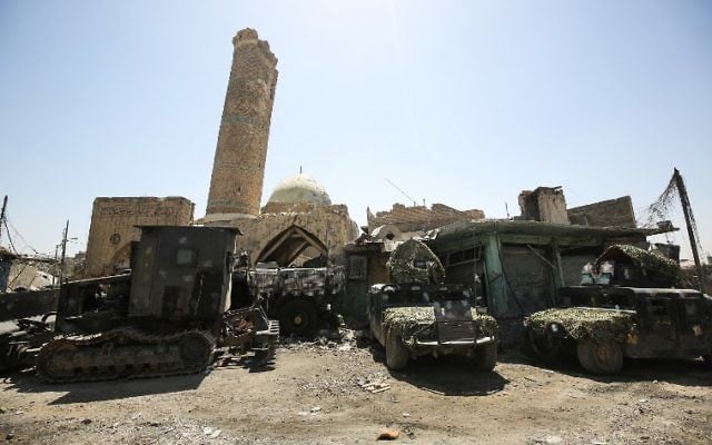 Iraqi federal police armored vehicles and humvees lie parked outside the damaged historic 19th century Ziwani mosque in the Old City of Mosul on June 28, 2017 (AFP/AHMAD AL-RUBAYE)
