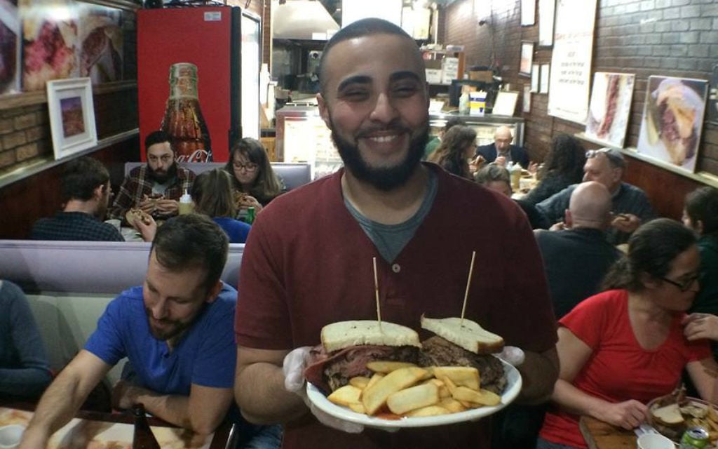 Sami from David's Brisket House in Bed-Stuy, Brooklyn, holding a delicious deli sandwich. (Courtesy BreakingBreadNYC) Sami from David's Brisket House in Bed-Stuy, Brooklyn, holding a delicious deli sandwich. (Courtesy BreakingBreadNYC)
