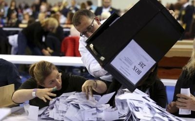 Ballot boxes are emptied to be counted for the general election, at the Emirates Arena in Glasgow, Scotland, Thursday June 8, 2017 (Andrew Milligan/PA via AP)