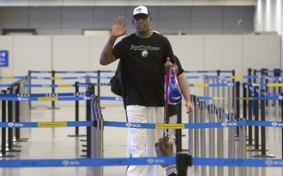 Former NBA basketball player Dennis Rodman gestures to photographers as he prepares to go through immigration at Beijing Capital International Airport in Beijing, Tuesday, June 13, 2017. (AP Photo/Mark Schiefelbein)