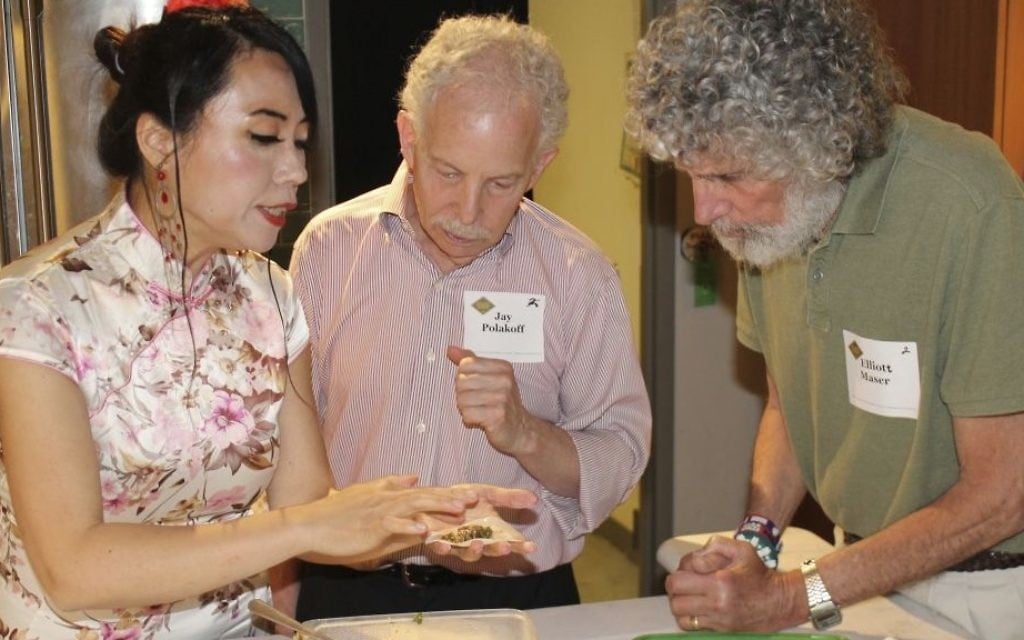 In this photo provided by Alex Styer, Alice Ye, left, demonstrates her technique for folding dumplings to Jay Polakoff, center, and Elliott Maser, right, during a June 5, 2017, dinner at Reading Terminal Market in Philadelphia. (Alex Styer/Bellevue Communications Group via AP) In this photo provided by Alex Styer, Alice Ye, left, demonstrates her technique for folding dumplings to Jay Polakoff, center, and Elliott Maser, right, during a June 5, 2017, dinner at Reading Terminal Market in Philadelphia. (Alex Styer/Bellevue Communications Group via AP)