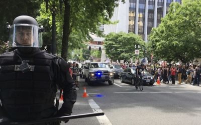 In this Sunday, June 4, 2017 file photo, thousands of protesters gather in Portland, Ore., for competing rallies following last month's fatal stabbing of two men on a light-rail train by a man police say was shouting anti-Muslim slurs.  (AP Photo/Kristena Hansen)