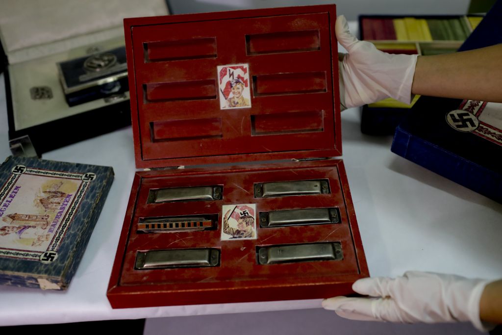 A member of the federal police shows a box with swastikas containing harmonicas for children at the Interpol headquarters in Buenos Aires, Argentina, June 16, 2017. (AP/Natacha Pisarenko) A member of the federal police shows a box with swastikas containing harmonicas for children at the Interpol headquarters in Buenos Aires, Argentina, June 16, 2017. (AP/Natacha Pisarenko)