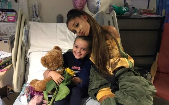 In this photo taken on Friday, June 2, 2017 provided by the Manchester Evening News, victim of the Manchester concert blast Lily Harrison hugs singer Ariana Grande during her visit to the Royal Manchester Children's Hospital, in Manchester, England. (Manchester Evening News via AP)