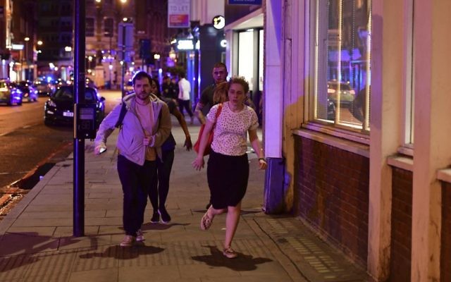 People run down Borough High Street as police deal with a "major incident" at London Bridge in London, June 3, 2017. (Dominic Lipinski/PA via AP)