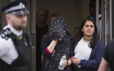 A person (C) is led away at an address in Barking, East London, during a police operation Sunday June 4, 2017, following Saturday night's terrorist incident at London Bridge. (Stefan Rousseau/PA via AP)