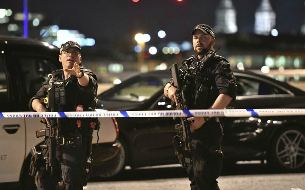 Armed police officers stand guard on London Bridge in central London, Saturday, June 3, 2017. (Dominic Lipinski/PA via AP)