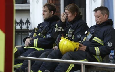 Firefighters wait to start their shift after a massive fire raged in a 24-floor high-rise apartment building in London, June 14, 2017. (AP/Matt Dunham) 