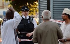 A police officer talks to local people at Finsbury Park in north London, where a vehicle struck pedestrians in north London Monday, June 19, 2017 (Victoria Jones/PA via AP)