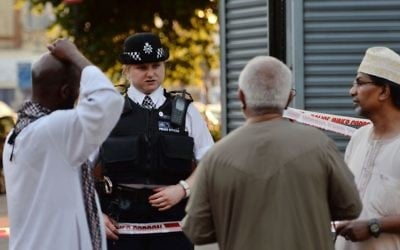A police officer talks to local people at Finsbury Park in north London, where a vehicle struck pedestrians in north London Monday, June 19, 2017 (Victoria Jones/PA via AP)