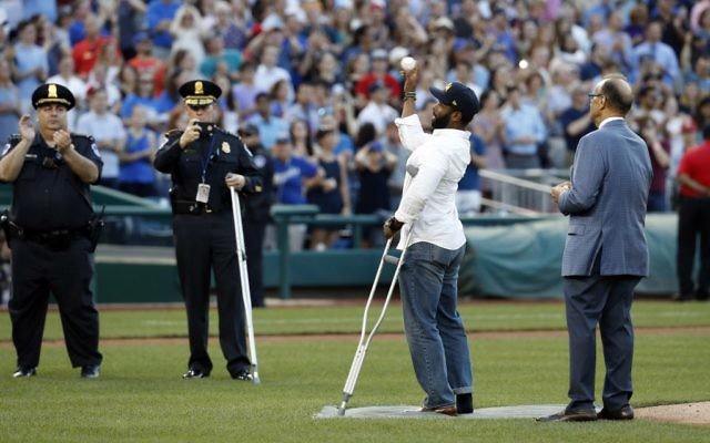 Injured Capitol Hill Police officer David Bailey throws out a ceremonial first pitch with Joe Torre, MLB's Chief Baseball Officer before the annual congressional baseball game, June 15, 2017. (AP Photo/Alex Brandon)