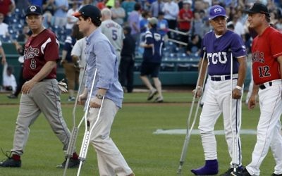 Injured aide Zach Barth (L) and Republican Congressman Roger Williams walk off the field before the annual congressional baseball game in Washington, DC, June 15, 2017. (AP Photo/Alex Brandon)