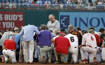 Rev. Patrick J. Conroy, Chaplain of the U.S. House of Representatives, prays as both teams kneel, before the Congressional baseball game, Thursday, June 15, 2017, in Washington. The annual GOP-Democrats baseball game raises money for charity. (AP Photo/Alex Brandon) 