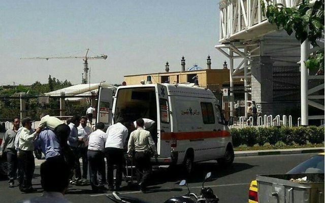 An injured police officer receives medical care outside the Iranian parliament after a shooting attack on Wednesday, June 7, 2017 (screen capture: Mehr news agency)