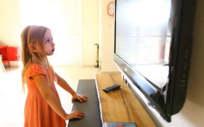 A young girl staring at a TV. (illustrative photo: Chen Leopold/Flash90)