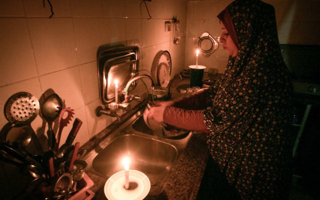 A Palestinian woman washes dishes by candlelight at her makeshift home in the Rafah refugee camp, in the southern Gaza Strip on June 12, 2017. (Abed Rahim Khatib/Flash90) A Palestinian woman washes dishes by candlelight at her makeshift home in the Rafah refugee camp, in the southern Gaza Strip on June 12, 2017. (Abed Rahim Khatib/Flash90)