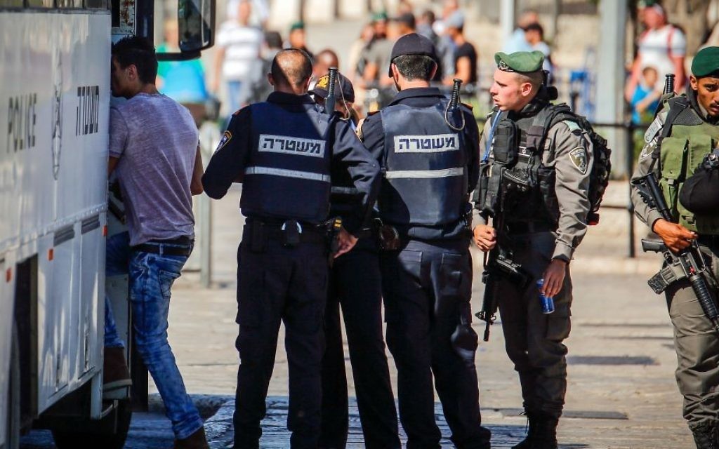 Security forces check a Palestinian man outside Damascus Gate in Jerusalem's Old City before he boards a bus to the West Bank on June 17, 2017. (Sliman Khader/Flash90)