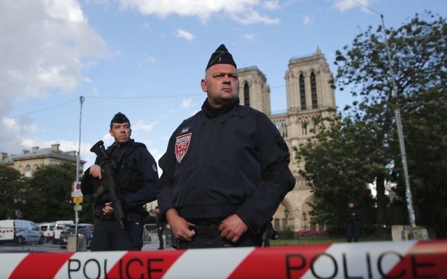 Police officers seal off the access to Notre Dame cathedral, seen in the background, after a man attacked officers with a hammer outside the famous landmark, in Paris, France, Tuesday, June 6, 2017. (AP Photo/Christophe Ena)