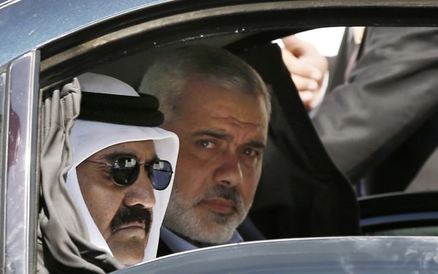 In this Oct. 23, 2012 photo, then-Emir of Qatar Sheikh Hamad bin Khalifa al-Thani, left, and Gaza's Hamas prime minister Ismail Haniyeh, arrive for a corner-stone laying ceremony for Hamad, a new residential neighborhood in Khan Younis, southern Gaza Strip. (AP Photo/Mohammed Salem, Pool)
