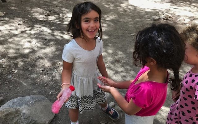 A girl helping her classmates wash their hands in Mitzpe Ramon, Israel, June 13, 2017. (Andrew Tobin) 