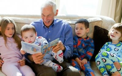 Illustrative: Harold Grinspoon, the founder of PJ Library, reads one of the program’s books with a gaggle of children. (PJ Library)