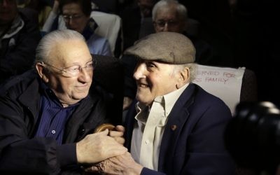 In this Wednesday, June 7, 2017 photo, Holocaust survivors Israel Arbeiter, left, and Steve Ross, right, greet one another at a theater before the premier of the film "Etched in Glass: The Legacy of Steve Ross," in West Newton, Mass. (AP Photo/Steven Senne) In this Wednesday, June 7, 2017 photo, Holocaust survivors Israel Arbeiter, left, and Steve Ross, right, greet one another at a theater before the premier of the film "Etched in Glass: The Legacy of Steve Ross," in West Newton, Mass. (AP Photo/Steven Senne)