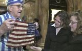 In this Nov. 11, 2012, still image from the film "Etched in Glass: The Legacy of Steve Ross," provided by Many Hats Productions, Holocaust survivor Steve Ross, from left, displays an American flag to Brenda Sattler and Gwen Sattler Allanson at a Veteran's Day event at the Statehouse in Boston. (Tony Bennis/Many Hats Productions via AP)