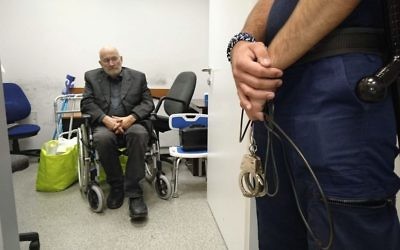 German extremist Horst Mahler, wanted by the German authorities, is guarded by a Hungarian policeman as he waits to be handed over to German police officers at Budapest Liszt Ferenc International Airport in Budapest, Hungary, Tuesday, June 13, 2017. (Zoltan Mihadak/MTI via AP)