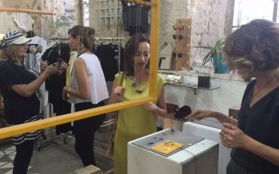 Customers browsing at Parallel, a studio and shop run by three designers in Jerusalem's Beit Alliance (Jessica Steinberg/Times of Israel)