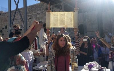 Illustrative: A young member of Women of the Wall holds up the miniature Torah scroll during the monthly Rosh Hodesh service on June 25, 2017, in the women's section of the Western Wall plaza. (Melanie Lidman/Times of Israel) Illustrative: A young member of Women of the Wall holds up the miniature Torah scroll during the monthly Rosh Hodesh service on June 25, 2017, in the women's section of the Western Wall plaza. (Melanie Lidman/Times of Israel)