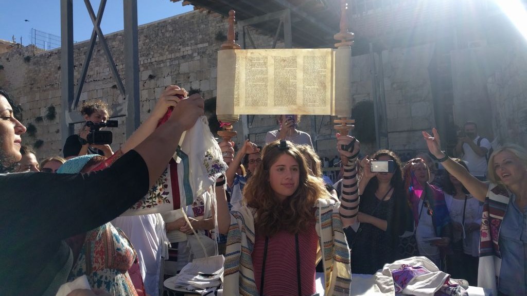 A young member of Women of the Wall holds up the miniature Torah scroll during the monthly Rosh Hodesh service on June 25, 2017, in the women's section of the Western Wall plaza, just before Netanyahu froze the Kotel Agreement. (Melanie Lidman/Times of Israel) A young member of Women of the Wall holds up the miniature Torah scroll during the monthly Rosh Hodesh service on June 25, 2017, in the women's section of the Western Wall plaza, just before Netanyahu froze the Kotel Agreement. (Melanie Lidman/Times of Israel)