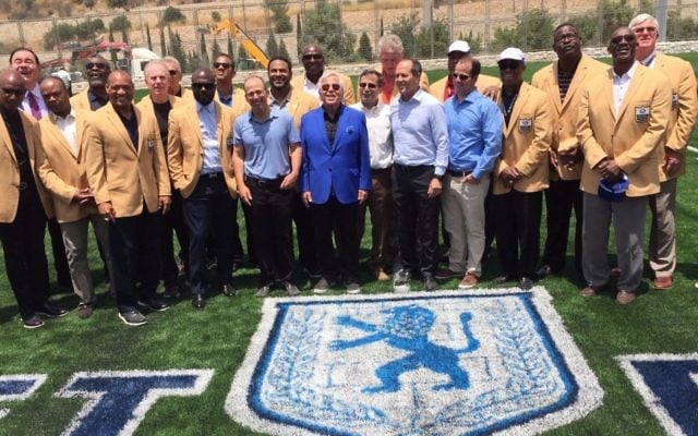 New England Patriots owner and philanthropist Robert Kraft (center, blue blazer) with most of the 18 NFL 'Gold Jackets' in Israel and at the ribbon-cutting ceremony in June, 2017 for Israel's first full-size American football field, part of the new Kraft Family Sports campus in Jerusalem (Jessica Steinberg/Times of Israel)