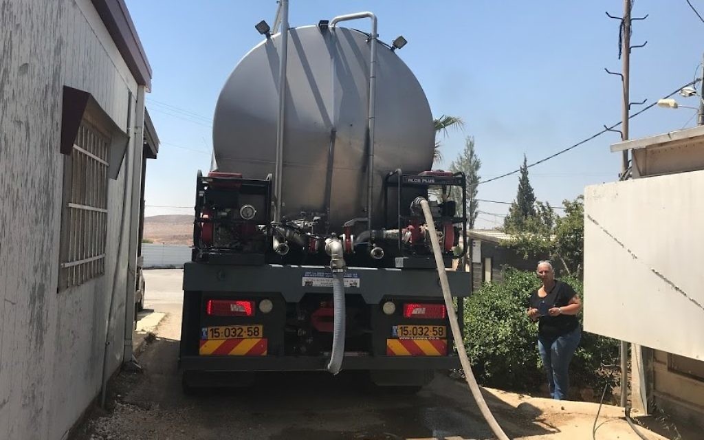 Migdalim settlement director Yael Hashash looks on as a tanker fills the settlements water tower on June 4, 2016. (Jacob Magid/Times of Israel) Migdalim settlement director Yael Hashash looks on as a tanker fills the settlements water tower on June 4, 2016. (Jacob Magid/Times of Israel)