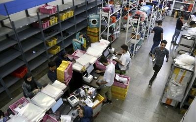In this Sunday, May 22, 2017, photo, staffers work at the fulfillment center of the Bamilo online shopping site in Tehran, Iran. (AP Photo/Ebrahim Noroozi)