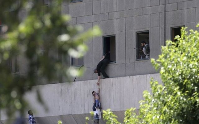 A man hands a child to a security guard from Iran's parliament building after an assault of several attackers, in Tehran, Iran, June 7, 2017 (Fars News Agency, Omid Vahabzadeh via AP) A man hands a child to a security guard from Iran's parliament building after an assault of several attackers, in Tehran, Iran, June 7, 2017 (Fars News Agency, Omid Vahabzadeh via AP)