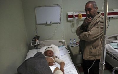 In this Saturday, March 4, 2017 file photo, Nazim Hamid stands next to his injured son Yasir, 11, a victim of a possible IS chemical attack in a hospital Irbil, Iraq (AP Photo/ Khalid Mohammed, File)