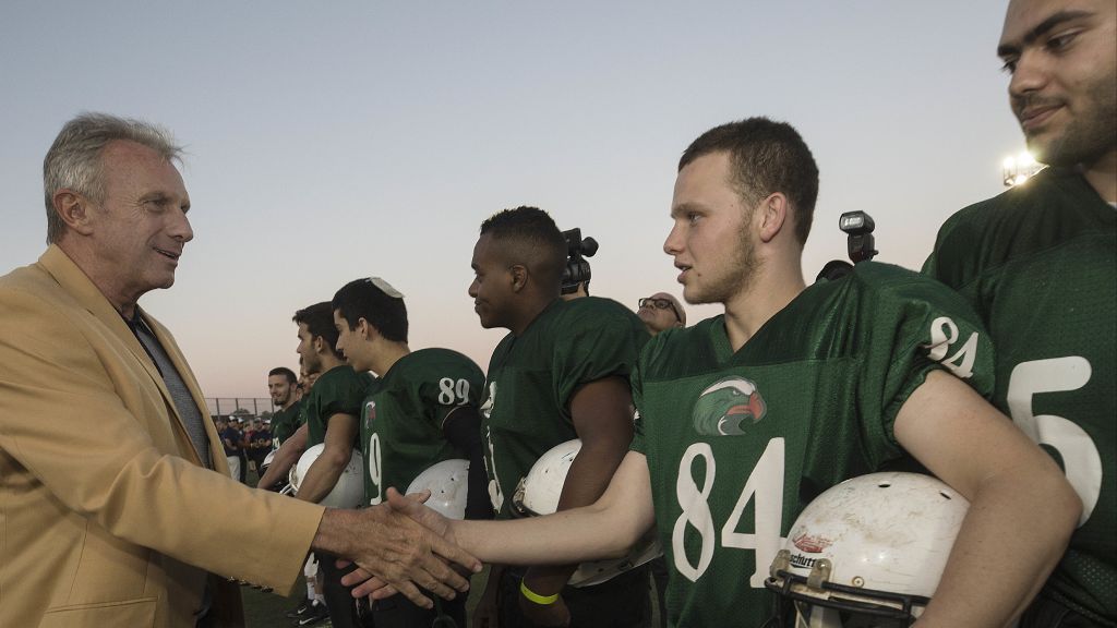 In this Thursday, June 15, 2017 photo, former NFL player Joe Montana shakes hands with an Israeli football player in Ramat Hasharon, near Tel Aviv, Israel. (AP Photo/Tsafrir Abayov)