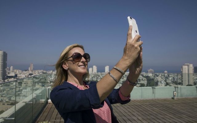 American Oscar-winning actress Marlee Matlin takes a selfie on the rooftop of the Tel Aviv municipality Monday, June 19, 2017. (AP Photo/Tsafrir Abayov)