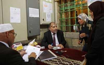 In this Monday, June 5, 2017 photo, the Mayor of Hebron Tayseer Abu Sneineh talks to people who have requests for help, inside a mosque in the West Bank city of Hebron. (AP/Nasser Shiyoukhi)